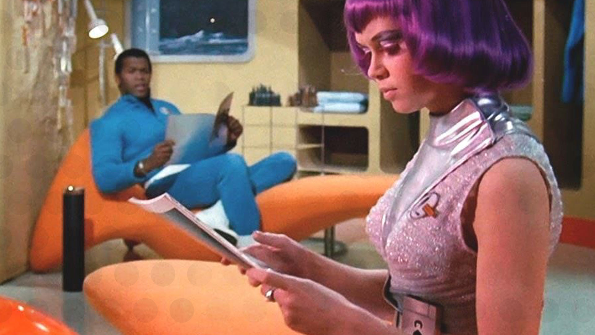Scene from UFO (1970) showing SHADO operatives in mod-influenced 1980s-set interiors - a woman in silver with a purple wig